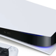 An image of a PlayStation 5 with the DualSensen controller lying in front of the console.